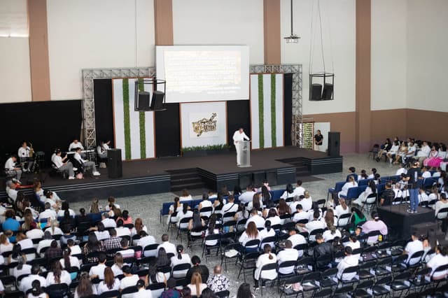 Congregación vestida de blanco reunida en el auditorio durante un servicio especial.
